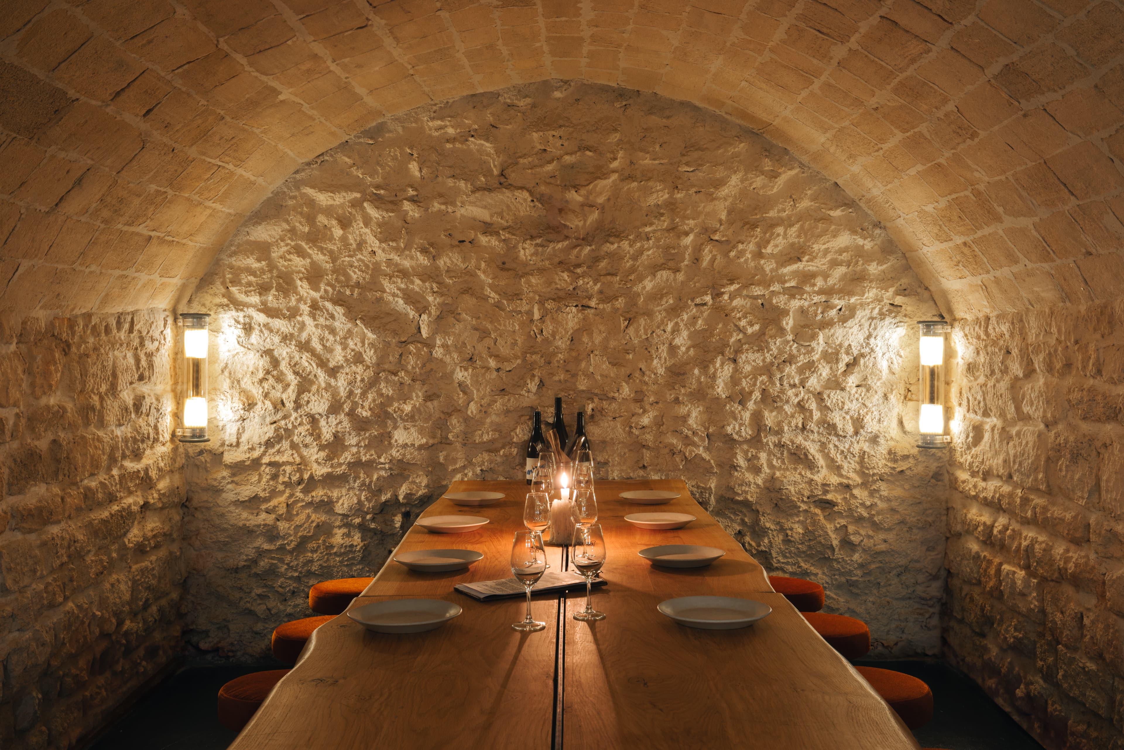 Salle du bas de Tempête : une cave voûtée en pierre avec une grande table en bois